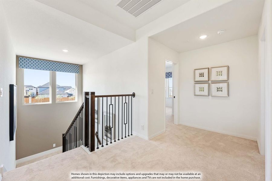 Upstairs hallway with carpet, wood and iron stair railing, and four framed wall art pieces near bedroom doorway. Upstairs hallway with carpet, wood and iron stair railing, and four framed wall art pieces near bedroom doorway.
