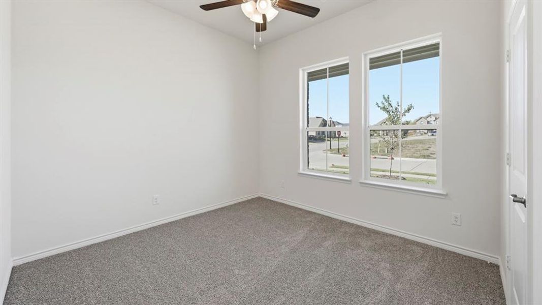 Empty room with carpet floors and a ceiling fan Empty room with carpet floors and a ceiling fan