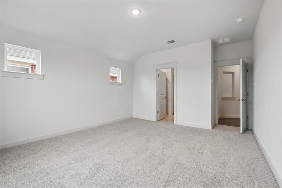 Unfurnished bedroom with light carpet and lofted ceiling Unfurnished bedroom with light carpet and lofted ceiling