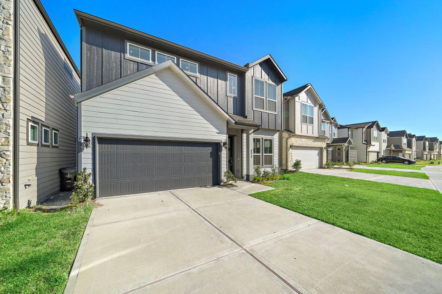 A two-car garage with a stylish paneled door offers convenience and seamlessly blends with the home’s exterior design. A two-car garage with a stylish paneled door offers convenience and seamlessly blends with the home’s exterior design.