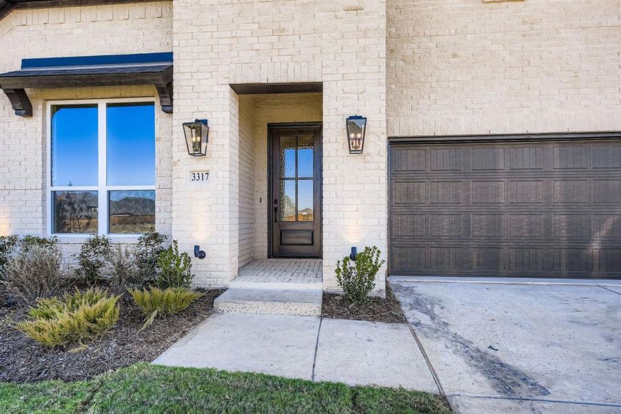 Entrance to property featuring brick siding and concrete driveway