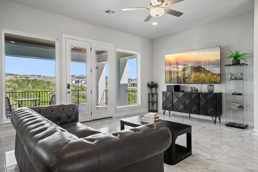 Living room with ceiling fan and light marble finish floors