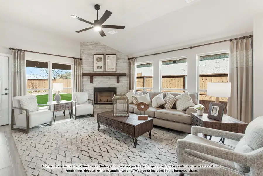 Living room with stone fireplace, ceiling fan, neutral sofa seating, and patio door access to backyard