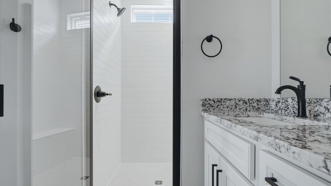 Accomplished design shines in this primary bath with dual vanity and a sleek walk-in shower at Fox Hollow