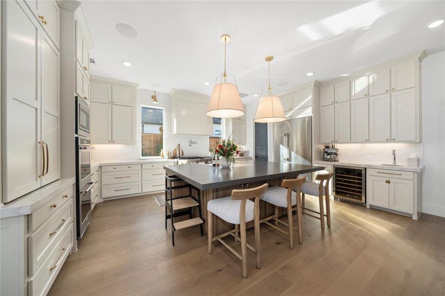 Kitchen featuring decorative backsplash, light wood-type flooring, white cabinetry, and wine cooler