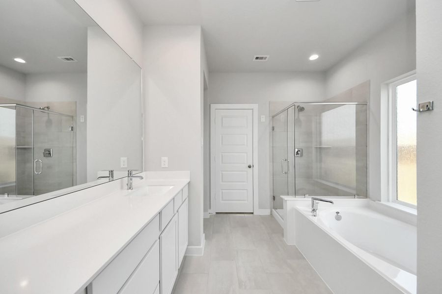 This additional view of the primary bath features a walk-in shower with the tile surround and separate garden tub perfect for soaking after a long day. This additional view of the primary bath features a walk-in shower with the tile surround and separate garden tub perfect for soaking after a long day.