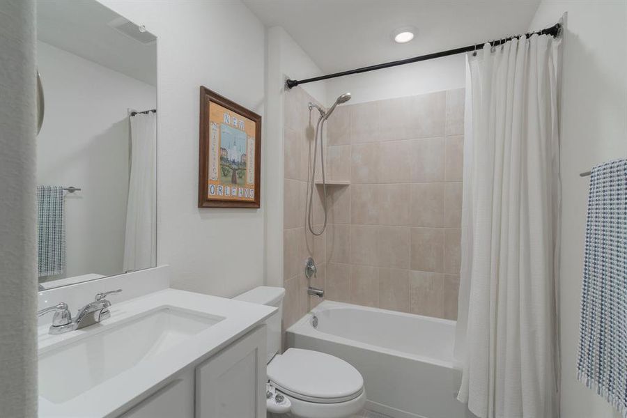 Bathroom with toilet, shower / tub combo, and vanity