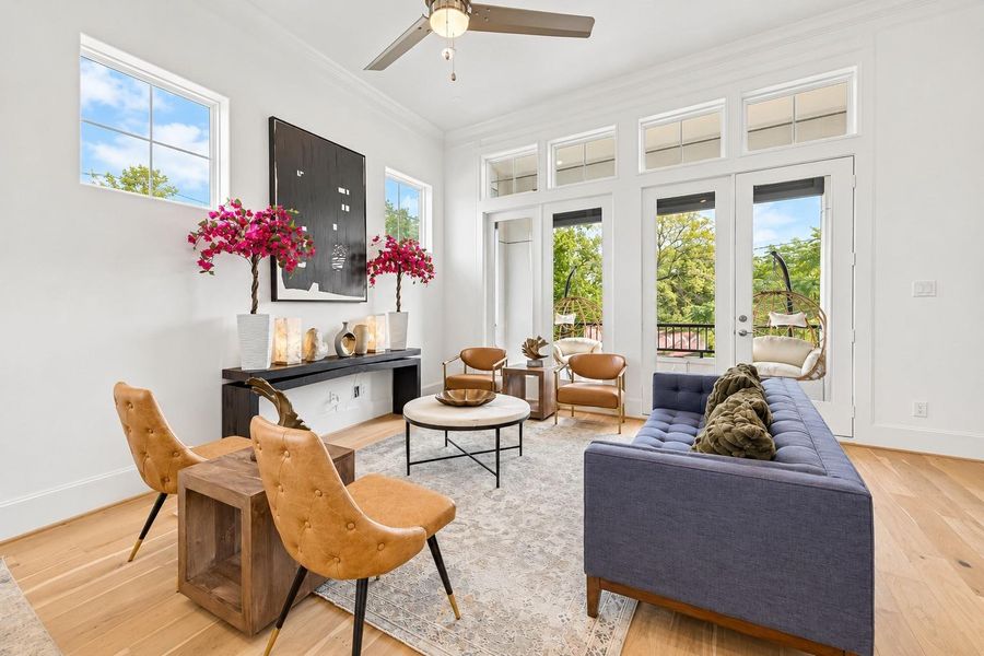 Eight ft tall doors to the balcony bathe the living area in sunlight.