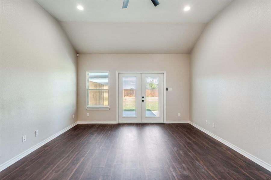 Empty room with dark wood-type flooring, french doors, vaulted ceiling, recessed lighting, and a ceiling fan Empty room with dark wood-type flooring, french doors, vaulted ceiling, recessed lighting, and a ceiling fan
