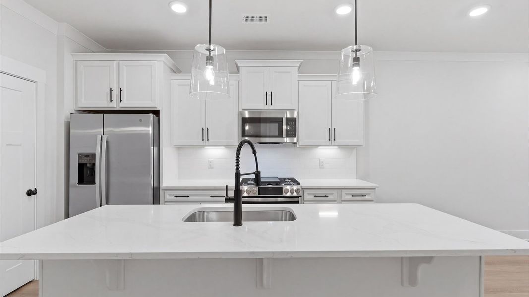 Notable kitchen space with elegant pendant lighting and a large island perfect for entertaining located in Greenville, SC