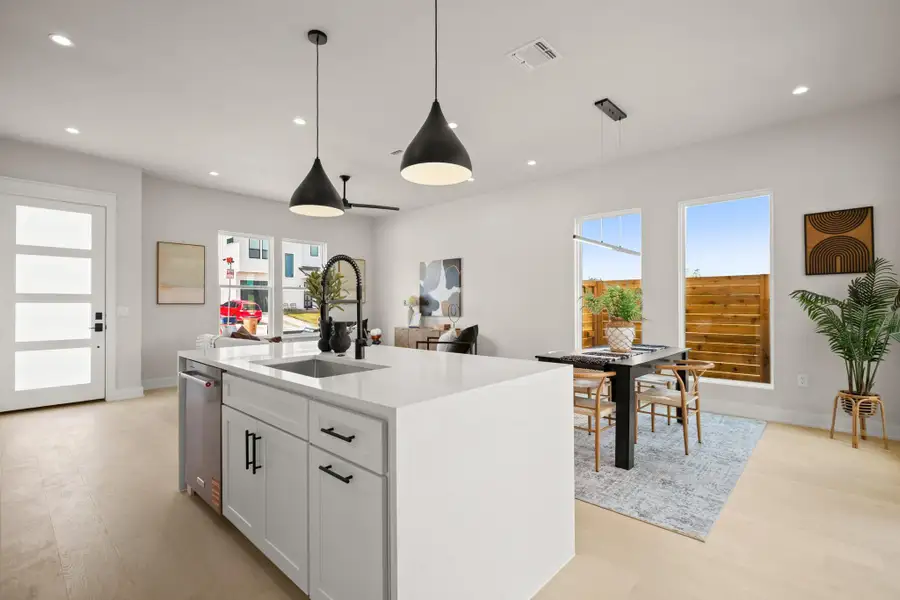 Kitchen featuring white cabinets, light stone countertops, recessed lighting, hanging light fixtures, and light wood-style floors