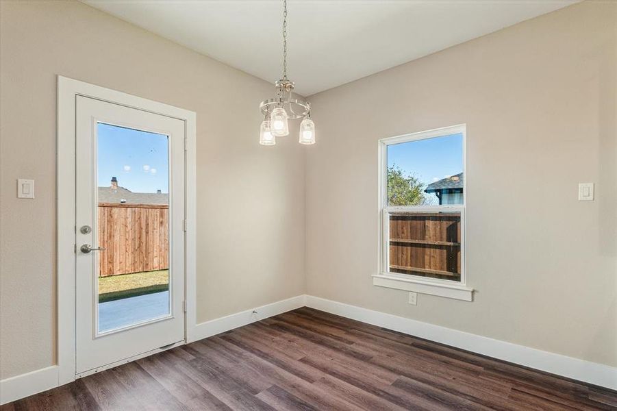 Unfurnished dining area featuring a wealth of natural light and dark wood-type flooring Unfurnished dining area featuring a wealth of natural light and dark wood-type flooring