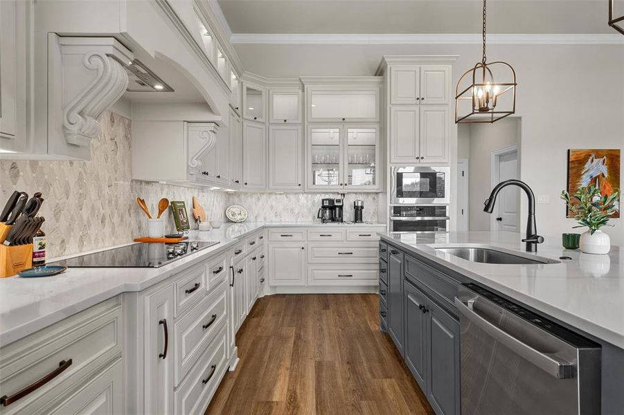 Kitchen with abundant cabinetry, decorative lighting, and breakfast bar seating at the island. Kitchen with abundant cabinetry, decorative lighting, and breakfast bar seating at the island.
