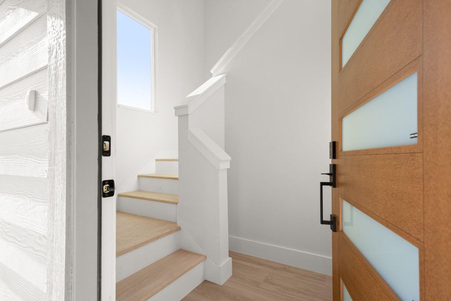 Stairway with wood finished floors and baseboards