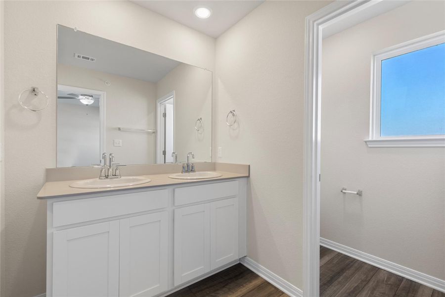 Bathroom with double vanity and dark wood-style flooring Bathroom with double vanity and dark wood-style flooring
