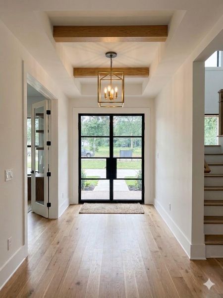 Inviting entry featuring wide-plank luxury vinyl flooring, exposed beam accents, designer lighting, and modern steel-framed front doors. Virtually Staged. Inviting entry featuring wide-plank luxury vinyl flooring, exposed beam accents, designer lighting, and modern steel-framed front doors. Virtually Staged.