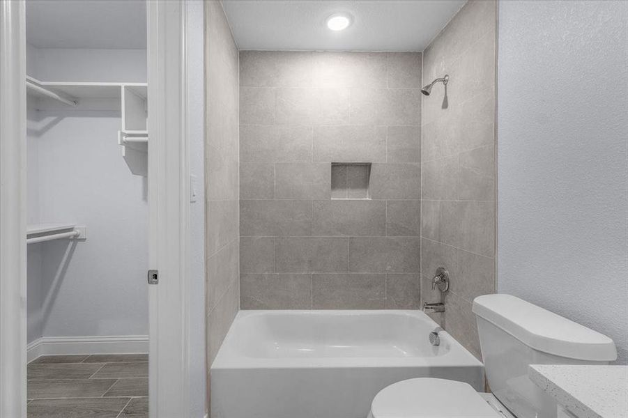 Bathroom featuring bathing tub / shower combination, a walk in closet, and vanity