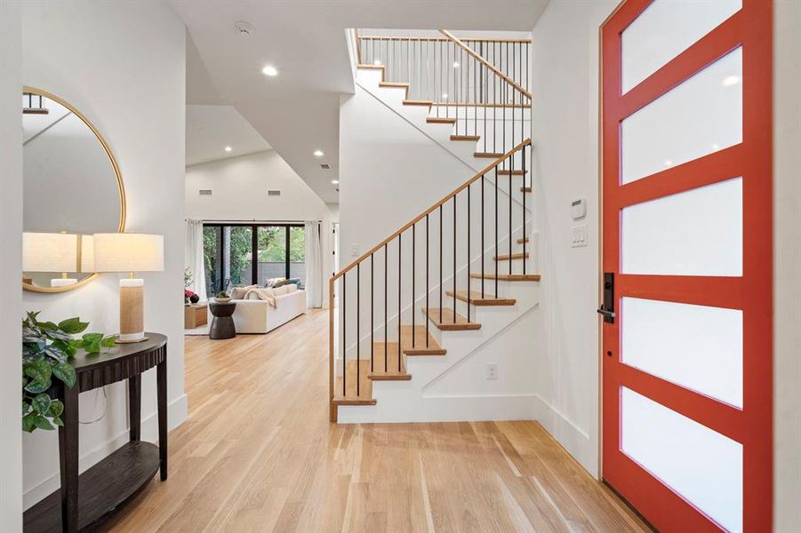 Entryway with wood finished floors, a towering ceiling, stairway, and recessed lighting Entryway with wood finished floors, a towering ceiling, stairway, and recessed lighting