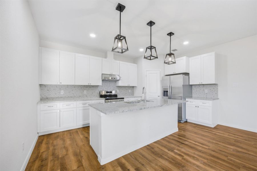 Culinary creations come to life in this kitchen, featuring an island for preparation and abundant cabinetry.