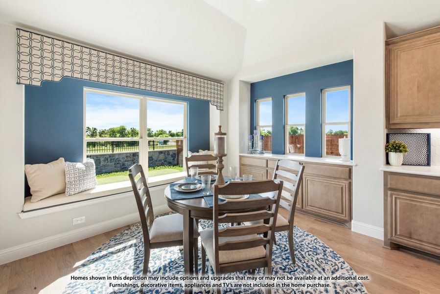 Breakfast nook with round dining table, window seat, blue accent walls, and hardwood floors Breakfast nook with round dining table, window seat, blue accent walls, and hardwood floors