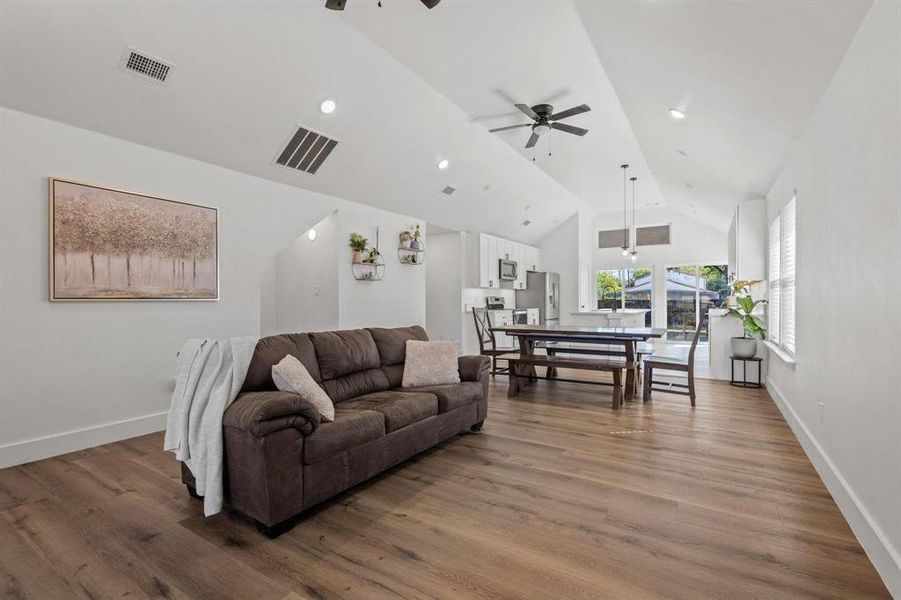 Living area featuring ceiling fan, wood finished floors, recessed lighting, and high vaulted ceiling