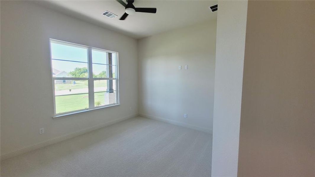 Carpeted room featuring a large multi-pane window, neutral wall tones, a ceiling fan with integrated lighting, and recessed ceiling lighting