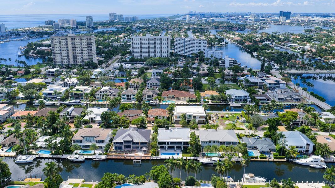A vibrant neighborhood scene showing waterfront homes leading toward the Fort Lauderdale coastline and ocean horizon. A vibrant neighborhood scene showing waterfront homes leading toward the Fort Lauderdale coastline and ocean horizon.