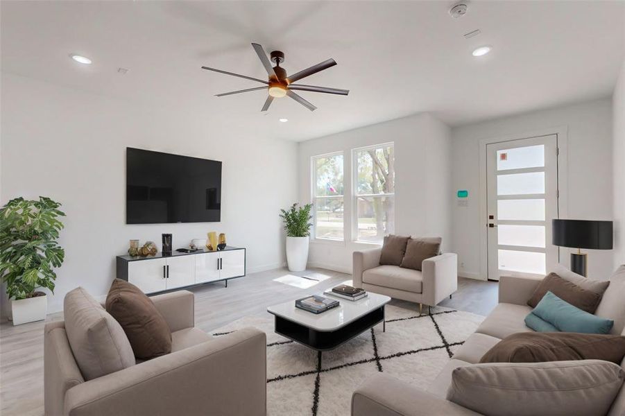 Living room with light hardwood / wood-style floors and ceiling fan