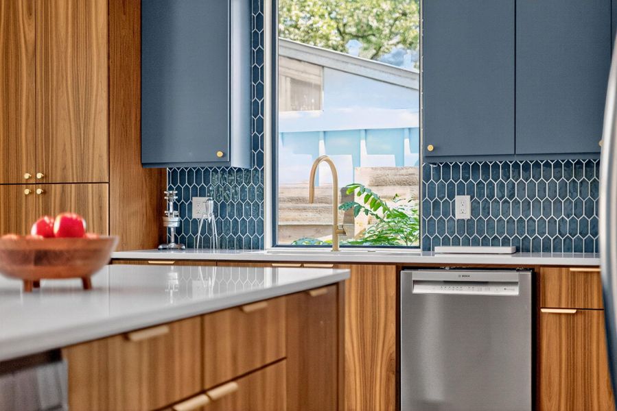Kitchen featuring stainless steel dishwasher, backsplash, and plenty of natural light