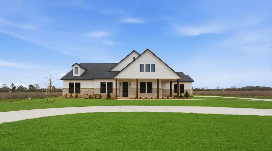 Front exterior of a new home in The Manors, New Waverly, TX, highlighting curb appeal (Image 1). Front exterior of a new home in The Manors, New Waverly, TX, highlighting curb appeal (Image 1).