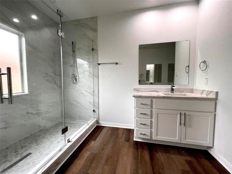 Bathroom with a shower with door, hardwood / wood-style flooring, and vanity