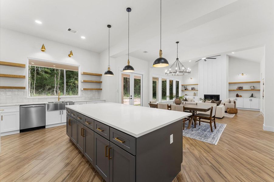 Chef’s dream kitchen featuring custom cabinetry, oversized island, quartz counters, modern fixtures, and abundant windows that overlook the backyard. Chef’s dream kitchen featuring custom cabinetry, oversized island, quartz counters, modern fixtures, and abundant windows that overlook the backyard.