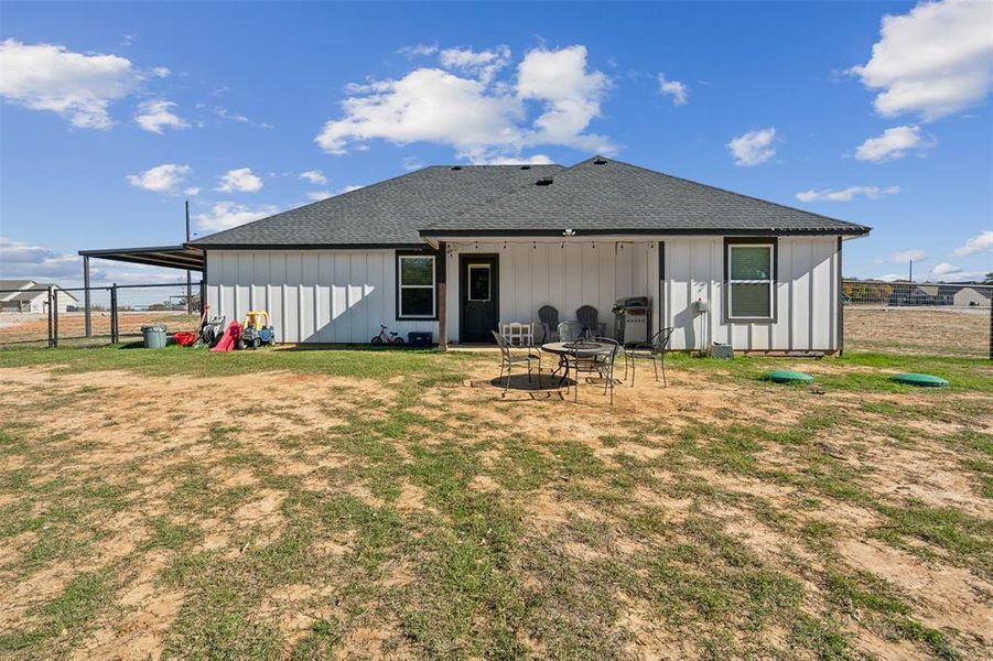 Rear view of house featuring a lawn and a fire pit