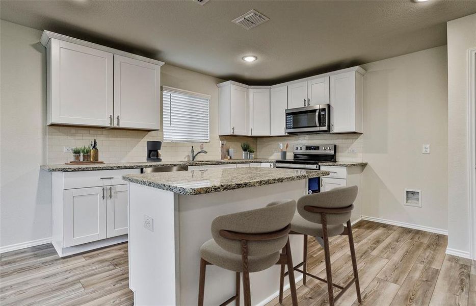 Spacious kitchen with oversized island  *Photos of furnished model. Not actual home. Representative of floor plan. Some options and features may vary