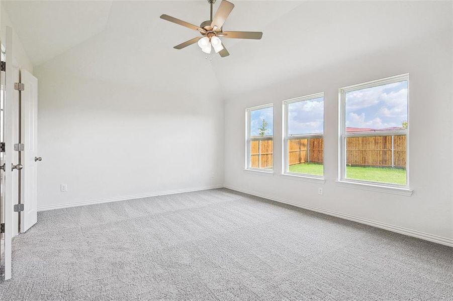 Carpeted spare room with high vaulted ceiling and ceiling fan