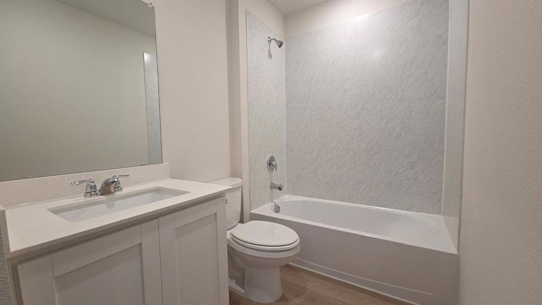 Bathroom featuring a white vanity with an integrated sink, polished chrome faucet, and a large mirror
