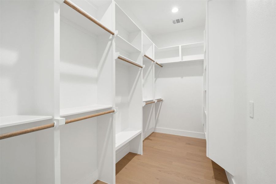 Ample storage solutions define this pristine, well-organized walk-in closet. Ample storage solutions define this pristine, well-organized walk-in closet.
