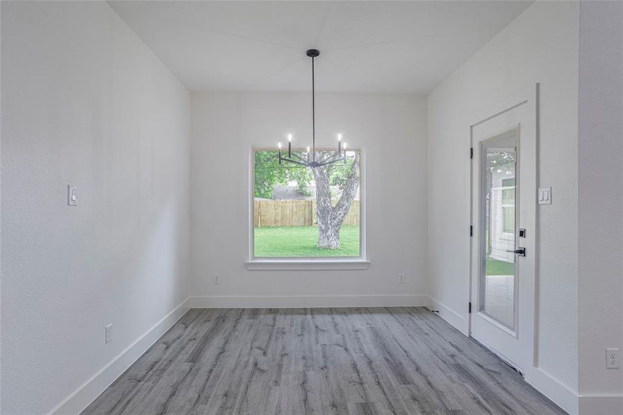 Unfurnished dining area with hardwood / wood-style flooring and an inviting chandelier