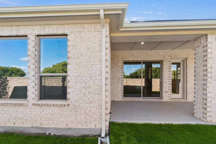 Doorway to property featuring a patio area and brick siding Doorway to property featuring a patio area and brick siding