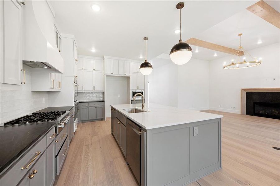 Kitchen featuring gray cabinetry, appliances with stainless steel finishes, light hardwood / wood-style floors, sink, and white cabinets