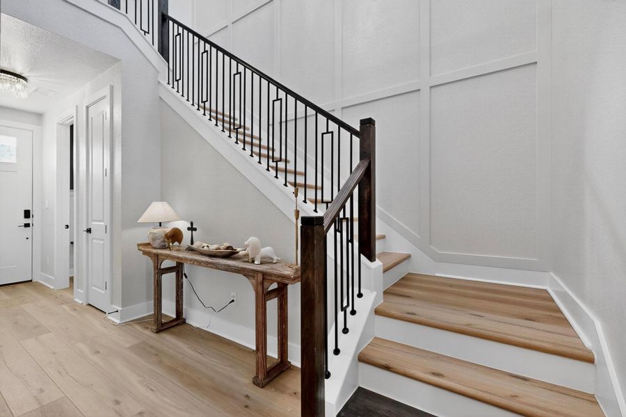 Stairs with wood finished floors and baseboards