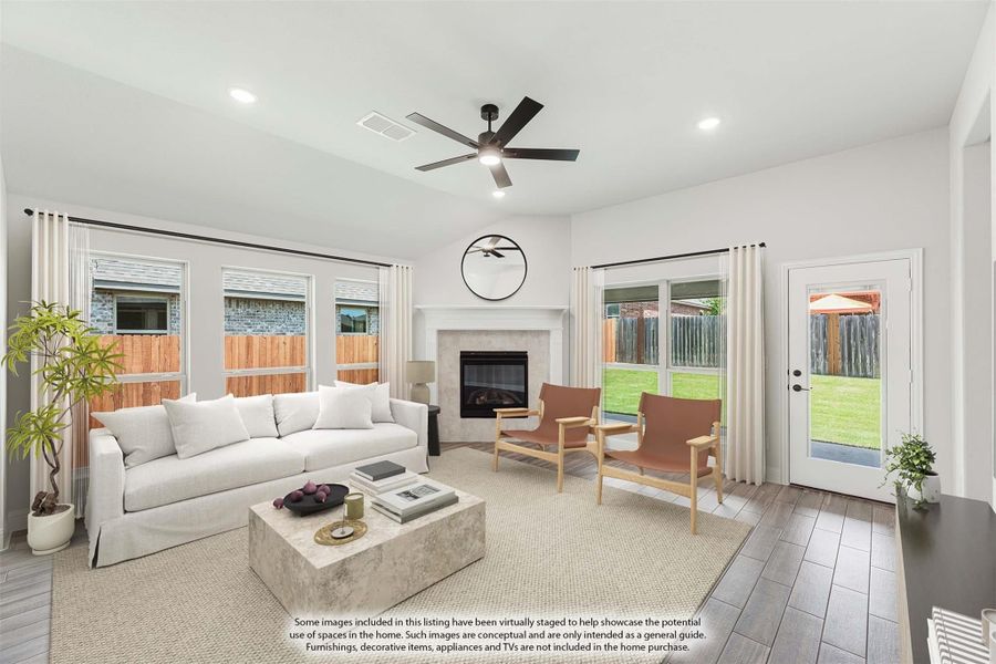 Living room with white sofa, fireplace, ceiling fan, and wood-look floors with backyard access door Living room with white sofa, fireplace, ceiling fan, and wood-look floors with backyard access door