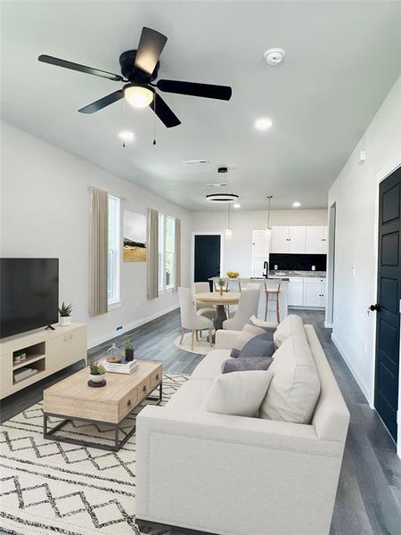 Living room featuring ceiling fan and hardwood / wood-style flooring