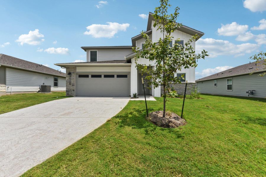 View of front of property with driveway, a front lawn, board and batten siding, and an attached garage View of front of property with driveway, a front lawn, board and batten siding, and an attached garage