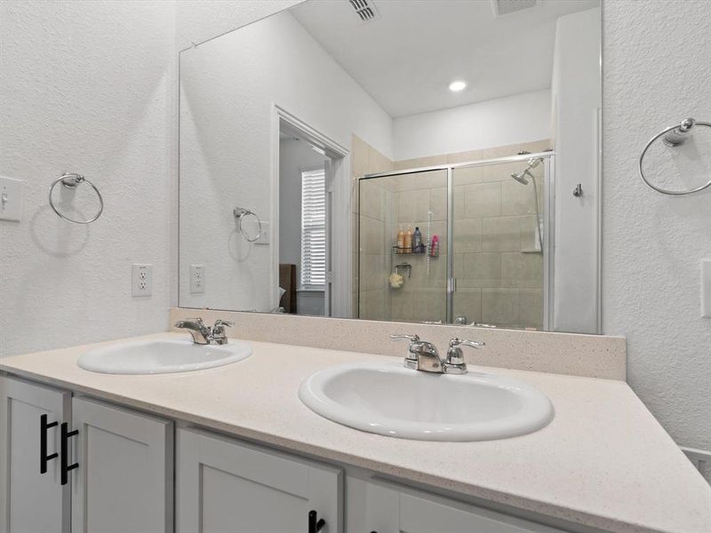 Bathroom featuring vanity and a shower with shower door