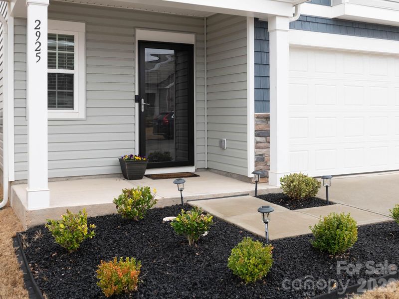 Covered front porch with beautiful landscaping.