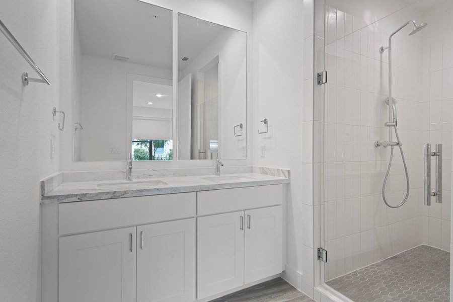 A sleek double vanity sits adjacent to a spacious glass-enclosed shower. A sleek double vanity sits adjacent to a spacious glass-enclosed shower.