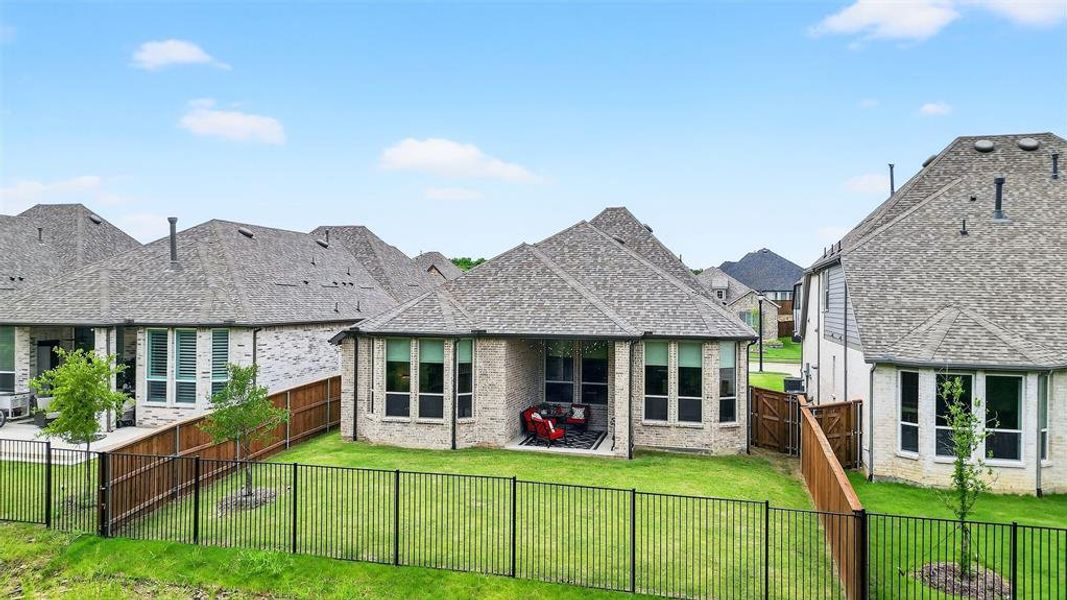 Back of house with a patio area, a fenced backyard, brick siding, and a residential view Back of house with a patio area, a fenced backyard, brick siding, and a residential view