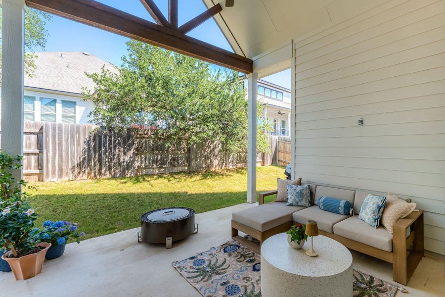 Covered patio featuring a sloped wood-beam ceiling, concrete flooring, and horizontal siding