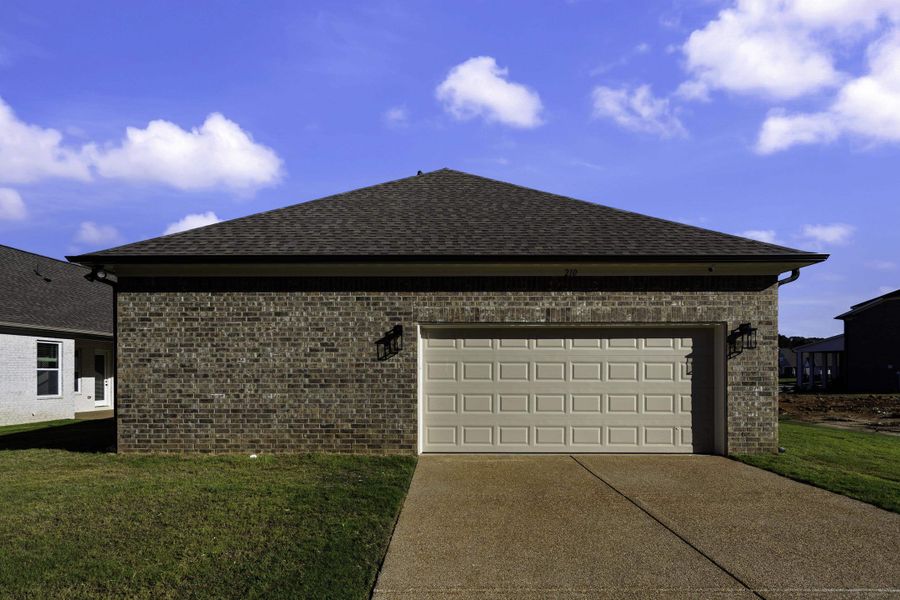 Brick exterior with a peaked roof and asphalt shingles